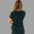 Back view of a woman in a bottle green 920 super stretch scrub top with crossed arms.