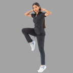 Women's black Style 930 scrub top, full body side view lifting one leg