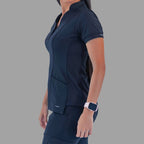 Side view of a woman wearing the navy blue Style 930 scrub top, showing the garment's fit and sleeve length.