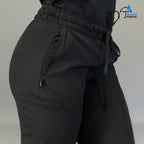 Detalle de pretina elástica y bolsa lateral en pantalón quirúrgico negro